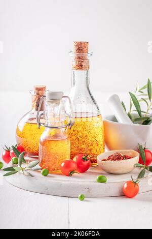 Leckeres und gesundes Öl in der Flasche mit getrockneten Tomaten. Produkte aus Oliven und getrockneten Tomaten. Stockfoto