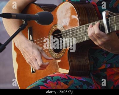 Frau macht Musik und spielt Gitarre Stockfoto