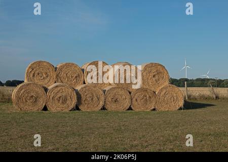 Rundballen aus Stroh, Windmotoren, Allerstorf, Marlow, Mecklenburg-Vorpommern, Deutschland Stockfoto