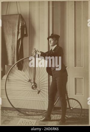 Frances Benjamin Johnston, Ganzkörperporträt, gekleidet als Mann mit falschem Schnurrbart, posiert mit Fahrrad, nach links, zwischen 1890 und 1900. [Frances Benjamin Johnston war Fotografin und Fotojournalistin]. Stockfoto