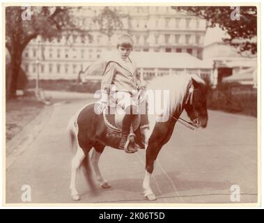 Archie Roosevelt über Pony, "Algonquin", 1902. Das Foto zeigt Archie Roosevelt auf seinem Pony mit dem State, war, and Navy Building, Washington, D.C., in der Ferne. Stockfoto