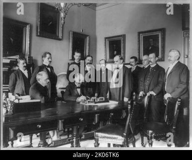 Unterzeichnung des Friedensprotokolls - Washington - 12.. August 1898, c1898. Eugene Thiebaut(?) Unterschreiben, als William McKinley und zehn andere Männer sich angucken. Stockfoto