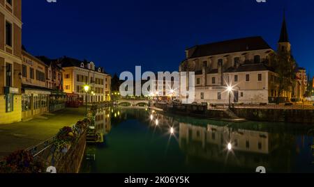 ANNECY, FRANKREICH - 11. JULI 2022: Die Altstadt in der Abenddämmerung mit der Kirche Saint Fracois de Sales. Stockfoto