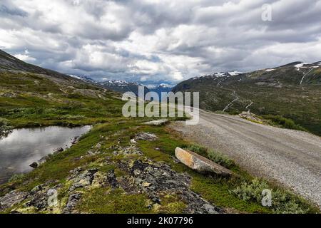 Schotterstraße durch karge Berglandschaft, beeindruckende Landschaftsroute Aursjovegen, Aursjovegen, Dovrefjell-Sunndalsfjella Nationalpark, Norwegen Stockfoto