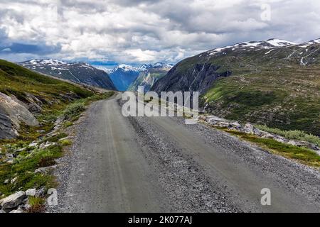 Schotterstraße durch karge Berglandschaft mit Schneeresten, beeindruckende Landschaftsroute Aursjovegen, Aursjovegen, Dovrefjell-Sunndalsfjella Stockfoto