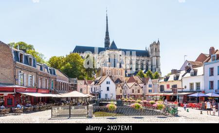 Notre-Dame d'Amiens Kathedrale mit Blick auf den Don Platz, gesäumt von historischen Stadthäusern, Straßencafés und Restaurants an einem sonnigen Sommertag. Stockfoto