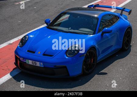 Blauer Sportwagen-Rennwagen Porsche 911 992 GT3 in der Boxengasse der Rennstrecke, FIA Formel 1-Rennstrecke, Circuit de Spa Francorchamps, Ardennen-Roller Stockfoto