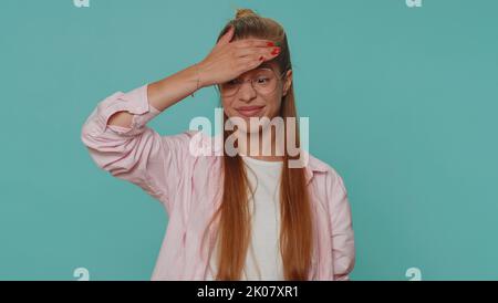 Gesichtshandfläche. Schande über dich. Verärgert ziemlich Teenager Mädchen macht Gesicht Handfläche Geste, sich gelangweilt, enttäuscht im Ergebnis, schlechte Nachrichten. Junge weibliche Kind Kind isoliert allein auf blauem Studio Hintergrund drinnen Stockfoto