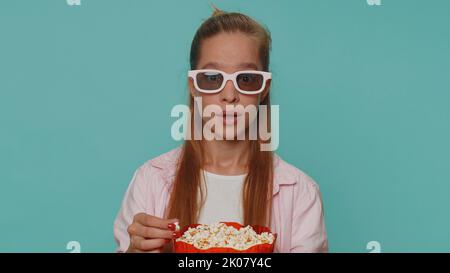 Aufgeregt Teenager Mädchen essen Popcorn und sehen interessante tv-Serie, Sportspiel-Film, Online-Social-Media-Film-Inhalte online. Schüler Kind Kind auf blauem Hintergrund genießen häusliche Unterhaltung Stockfoto