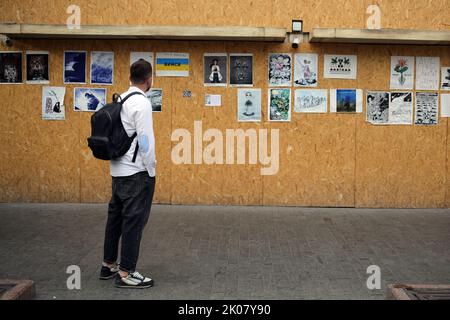 Odessa, Ukraine. 09. September 2022. Ein Mann sieht sich die Antikriegsplakate der Ave Libertatemaveamor entlang der Deribasowskaja Straße, Odesa, an. Seit Beginn des umfassenden Krieges Russlands gegen die Ukraine sind viele Einzelhandelsbetriebe aus Sicherheitsgründen gezwungen, ihre Fenster mit schützenden Holzkonstruktionen zu bedecken. Es ist zu einer Art Ausstellungsraum für viele Künstler geworden, die ihre Antikriegsarbeiten an Holzkonstruktionen hängen. (Foto: Viacheslav Onyshchenko/SOPA Images/Sipa USA) Quelle: SIPA USA/Alamy Live News Stockfoto