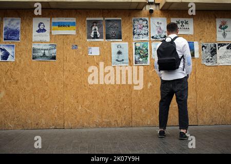 Odessa, Ukraine. 09. September 2022. Ein Mann sieht sich die Antikriegsplakate der Ave Libertatemaveamor entlang der Deribasowskaja Straße, Odesa, an. Seit Beginn des umfassenden Krieges Russlands gegen die Ukraine sind viele Einzelhandelsbetriebe aus Sicherheitsgründen gezwungen, ihre Fenster mit schützenden Holzkonstruktionen zu bedecken. Es ist zu einer Art Ausstellungsraum für viele Künstler geworden, die ihre Antikriegsarbeiten an Holzkonstruktionen hängen. (Foto: Viacheslav Onyshchenko/SOPA Images/Sipa USA) Quelle: SIPA USA/Alamy Live News Stockfoto