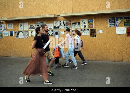 Odessa, Ukraine. 09. September 2022. Die Menschen gehen an den Antikriegsplakaten der Ave Libertatemaveamor entlang der Deribasowskaya-Straße, Odesa, vorbei. Seit Beginn des umfassenden Krieges Russlands gegen die Ukraine sind viele Einzelhandelsbetriebe aus Sicherheitsgründen gezwungen, ihre Fenster mit schützenden Holzkonstruktionen zu bedecken. Es ist zu einer Art Ausstellungsraum für viele Künstler geworden, die ihre Antikriegsarbeiten an Holzkonstruktionen hängen. (Foto: Viacheslav Onyshchenko/SOPA Images/Sipa USA) Quelle: SIPA USA/Alamy Live News Stockfoto