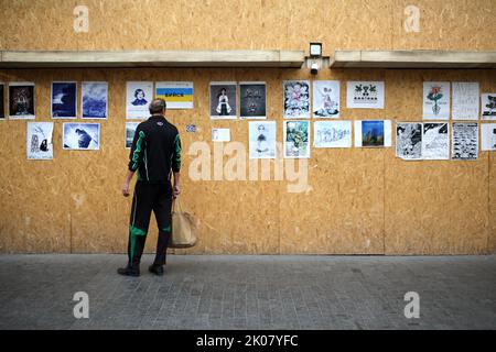 Odessa, Ukraine. 09. September 2022. Ein Mann sieht sich die Antikriegsplakate der Ave Libertatemaveamor entlang der Deribasowskaja Straße, Odesa, an. Seit Beginn des umfassenden Krieges Russlands gegen die Ukraine sind viele Einzelhandelsbetriebe aus Sicherheitsgründen gezwungen, ihre Fenster mit schützenden Holzkonstruktionen zu bedecken. Es ist zu einer Art Ausstellungsraum für viele Künstler geworden, die ihre Antikriegsarbeiten an Holzkonstruktionen hängen. (Foto: Viacheslav Onyshchenko/SOPA Images/Sipa USA) Quelle: SIPA USA/Alamy Live News Stockfoto