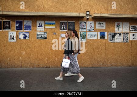 Odessa, Ukraine. 09. September 2022. Die Menschen gehen an den Antikriegsplakaten der Ave Libertatemaveamor entlang der Deribasowskaya-Straße, Odesa, vorbei. Seit Beginn des umfassenden Krieges Russlands gegen die Ukraine sind viele Einzelhandelsbetriebe aus Sicherheitsgründen gezwungen, ihre Fenster mit schützenden Holzkonstruktionen zu bedecken. Es ist zu einer Art Ausstellungsraum für viele Künstler geworden, die ihre Antikriegsarbeiten an Holzkonstruktionen hängen. (Foto: Viacheslav Onyshchenko/SOPA Images/Sipa USA) Quelle: SIPA USA/Alamy Live News Stockfoto