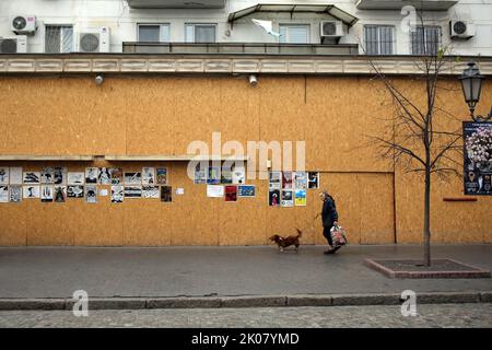 Odessa, Ukraine. 09. September 2022. Eine Frau mit ihrem Hund geht an Antikriegsplakaten der Ave Libertatemaveamor entlang der Deribasovskaya-Straße, Odesa, vorbei. Seit Beginn des umfassenden Krieges Russlands gegen die Ukraine sind viele Einzelhandelsbetriebe aus Sicherheitsgründen gezwungen, ihre Fenster mit schützenden Holzkonstruktionen zu bedecken. Es ist zu einer Art Ausstellungsraum für viele Künstler geworden, die ihre Antikriegsarbeiten an Holzkonstruktionen hängen. (Foto: Viacheslav Onyshchenko/SOPA Images/Sipa USA) Quelle: SIPA USA/Alamy Live News Stockfoto