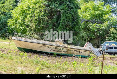 Dans Außenborddienst wird auf der Seite eines alten Bootes angepriesen Stockfoto