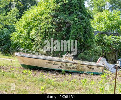 Dans Außenborddienst wird auf der Seite eines alten Bootes angepriesen Stockfoto