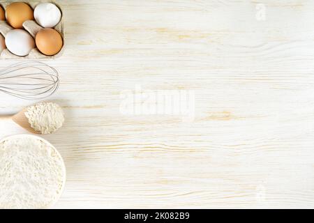 Backen Kochen Zutaten Hintergrund mit Kopierraum. Mehl, Eier, Milch auf weißer Holzoberfläche. Draufsicht, flach liegend. Modup-Menü, Banner, Header für Stockfoto