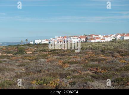 Porto Covo, Alentejo, Portugal, 25. Oktober 2021: Eine Gruppe touristischer Wanderer verlässt Porto Covo mit blauen und weißen Häusern, Beginn der Fischerwanderung Stockfoto