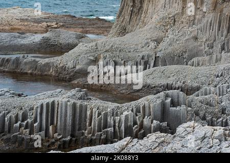 Küstenlandschaft mit wunderschönen säulenförmigen Basaltklippen bei Ebbe Stockfoto