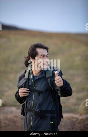 Ein mittelerwachsener chinesischer Mann, der unterwegs mitfährt Stockfoto