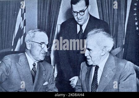 Präsident Harry S. Truman (links) trifft sich mit dem israelischen Premierminister David Ben-Gurion (rechts) und dem israelischen Botschafter Abba Eban (stehend) bei einer Geschenkzeremonie im Oval Office. 8.Mai 1951 Stockfoto