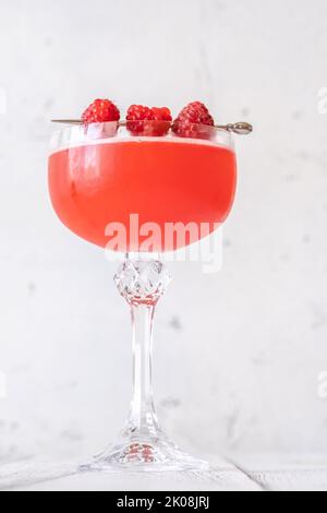 Ein Glas Blinker Cocktail garniert mit Himbeeren Stockfoto