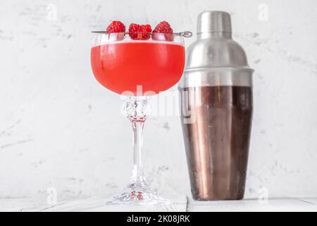 Ein Glas Blinker Cocktail garniert mit Himbeeren Stockfoto