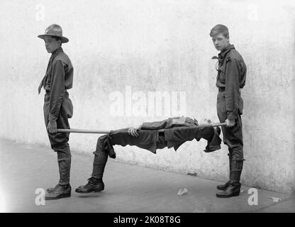 Vorführung Des Pfadfindertrainings, 1912. [Improvisierte Trage aus zwei Stangen und Kleidung]. Stockfoto