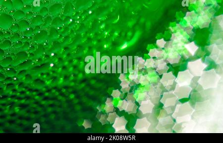 Grüne Glasflasche, selektiver Fokus, schönes unscharfes Bokeh. Nahaufnahme. Wassertropfen auf dem Glas, die im Bokeh in Form eines sechseckigen vorbeigehen Stockfoto