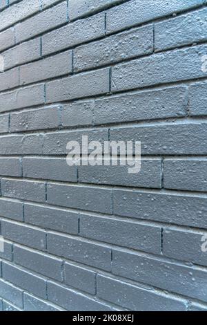 Nahaufnahme einer strukturierten Ziegelwand mit geometrischem Design eines Gebäudes. Außen- oder Innenwand mit geometrischem und symmetrischem Muster im Stil i Stockfoto