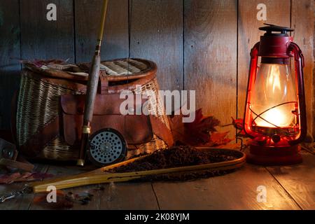 Vintage Fliegenfischerrute Kreel und Netz mit Laterne auf alten Grunge Holz Hintergrund Stockfoto