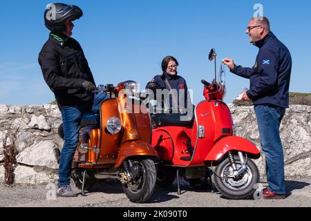 Roter Vespa-Roller mit goldenem, braunem Lambretta-Roller bei der jährlichen Rallye. Ballintoy, Großbritannien - 10. September 2022. Stockfoto