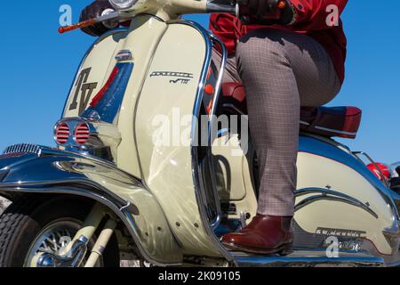 Lambretta TV 175, glänzender italienischer Vintage-Roller aus nächster Nähe fotografiert, Mann reitet. Ballintoy, Großbritannien - 10. September 2022. Stockfoto