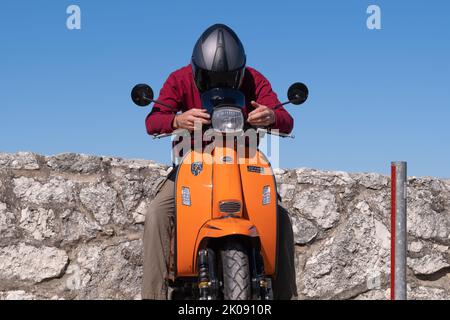 Der Roller Royal Alloy GT in Orange ist bereit für die Fahrt nach Portrush, wo die Clans-Roller-Rallye stattfindet. Ballintoy, Großbritannien - 10. September 2022. Stockfoto