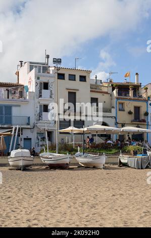 Blanes, Katalonien, Spanien -August 04,2022: Häuser in der Küstenstadt Blanes an der Costa Brava mit Fischerbooten vor der Küste und der Flagge von Cataloni Stockfoto