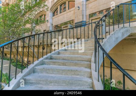 Treppen hinauf zu Gebäuden und einer Brücke mit Blick auf den San Antonio River Walk. Nahaufnahme der Betontreppe am berühmten Kanal für Touristen Stockfoto