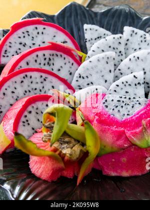 Platte aus geschnittener Drachenfrucht, Pitahaya oder Pitaya, aus der Familie Cactaceae, die Frucht mehrerer verschiedener Kaktusarten. Stockfoto