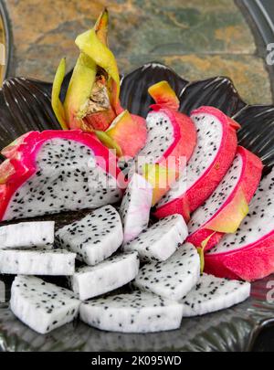 Platte aus geschnittener Drachenfrucht, Pitahaya oder Pitaya, aus der Familie Cactaceae, die Frucht mehrerer verschiedener Kaktusarten. Stockfoto