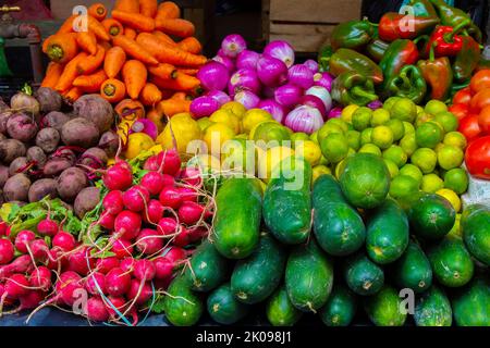 Frische Produkte, Obst und Gemüse, zum Verkauf in skurrilen Hüten zum Verkauf in gebratenem Schweinebraten zum Verkauf auf dem Otavalo Markt im Andenhochland nördlich von Quito Ecuador Stockfoto