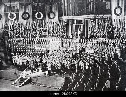 British Legion Festival of Remembrance in der Royal Albert Hall während der National Anthem. Als die neu gegründete britische Legion den Mohn als Emblem der Erinnerung annahm und am 11.. November 1921 den ersten britischen Spendenaufruf zum Poppy Day abhielt, tauchte sie auf eine starke emotionale Verbindung zwischen dem Mohn und der Erinnerung, die Veteranenorganisationen anderswo hergestellt hatten, inspiriert von McCraes Gedicht. Stockfoto