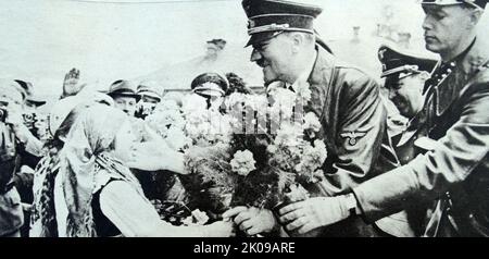 Adolf Hitler küsst ein Kind in Marburg, fotografiert von Heinrich Hoffmann. Heinrich Hoffmann (12. September 1885 - 15. Dezember 1957) war Adolf Hitlers offizieller Fotograf und ein Nazi-Politiker und Verleger, der Mitglied des intimen Hitlerkreises war. Adolf Hitler (20. April 1889 - 30. April 1945) war ein in Österreich geborener deutscher Politiker, der von 1933 bis zu seinem Tod 1945 der Diktator Deutschlands war. Er stieg als Führer der Nazi-Partei an die Macht, wurde 1933 Kanzler und übernahm 1934 den Titel eines Führers und Reichskanzlers. Während seiner Diktatur initiierte er World Stockfoto