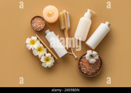 Badeset mit brennender Kerze und tropischen Blumen auf farbigem Hintergrund Stockfoto