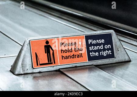 Ein Schild auf der Londoner U-Bahn, um rechts zu stehen und den Handlauf zu halten. Stockfoto