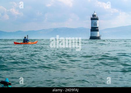 Seekajakfahren in der Nähe des Trwyn Du Lighthouse, auch bekannt als Penmon Lighthouse, vor der Puffin Island an der Küste von Anglesey, Wales, Großbritannien Stockfoto