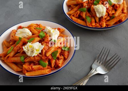 Hausgemachter Penne Alla Vodka mit Speck, Käse und Basilikum Stockfoto