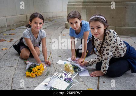 London UK 10. September 2022 - Junge Mädchen schreiben Botschaften und bringen Blumen - Trauernde versammeln sich am Buckingham Palace Blumen platzieren und ihre Achtung bezahlen - Königin Elizabeth, die zweite, starb gestern in ihrem Platinum Jubillee Jahr in Balmoral Castle. Foto Horst A. Friedrichs Alamy Live News Stockfoto