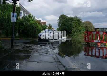 London, England, Großbritannien. 10.. September 2022. Autos, die nach Gewittern von einem überfluteten Ufer der Themse in die Chiswick Lane einbiegen. Cristina Massei/Alamy Live News Stockfoto