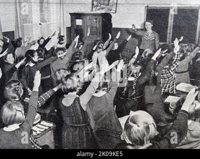 Deutsche Schulkinder, die den Nazi-Gruß verführen. Nazi-Deutschland, offiziell bekannt als Deutsches Reich von 1933 bis 1943, und das Großdeutsche Reich von 1943 bis 1945, war der deutsche Staat zwischen 1933 und 1945, als Adolf Hitler und die Nazi-Partei das Land kontrollierten und es in eine Diktatur verwandelten. Stockfoto