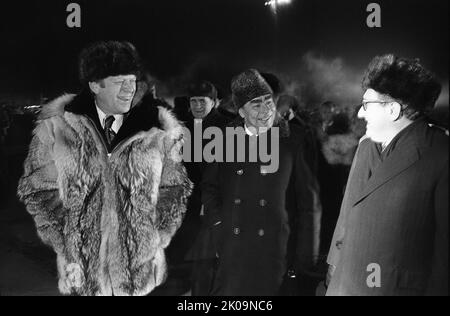 Präsident Gerald Ford, Generalsekretär Lenoid Breschnev und Henry Kissinger sprachen informell zum Abschluss des Wladiwostok-Gipfels auf dem Asphalt am Flughafen Wozdvizhenka. Nur wenige Augenblicke nach der Aufnahme dieses Fotos schloss Präsident Ford den Wladiwostok-Gipfel informell mit seinem wolfskin-Mantel an Minister Breschnew ab. 1974. Stockfoto